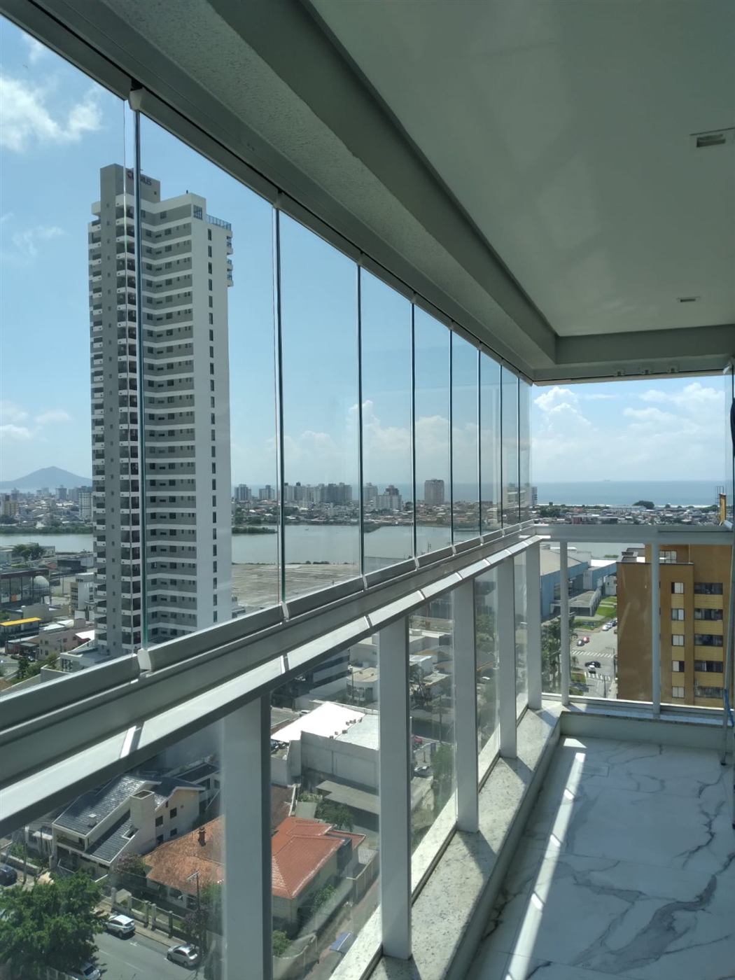 Ambiente de sacada envidraçada com vista para a cidade