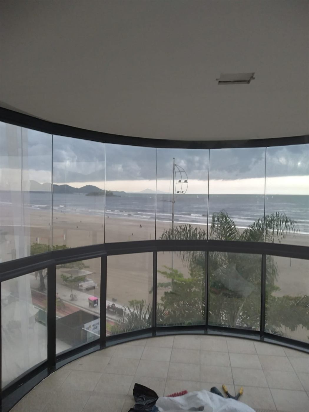 Envidraçamento de sacada com vista para orla e piscina