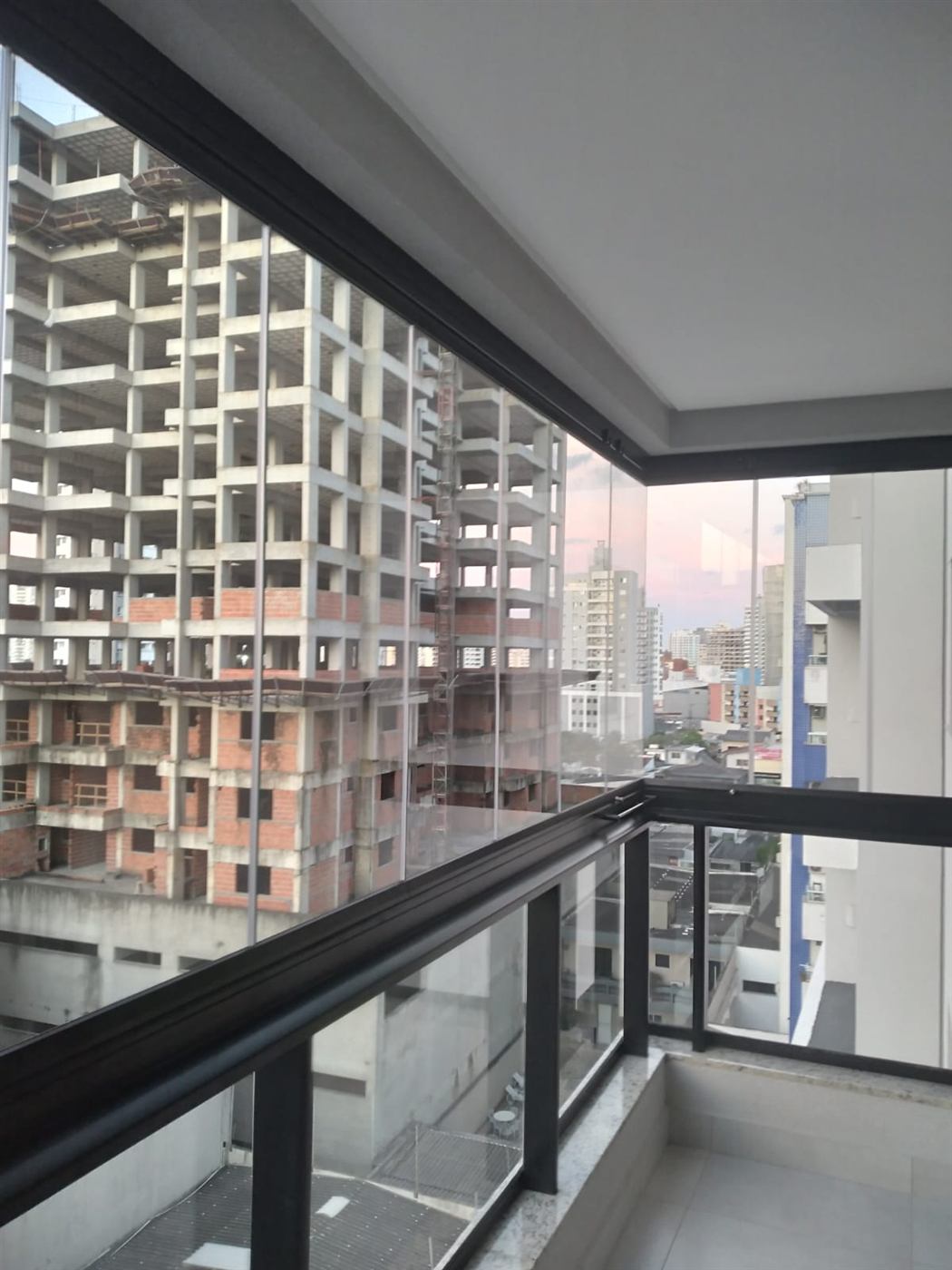 Envidraçamento de sacada ao entardecer com vista para a cidade