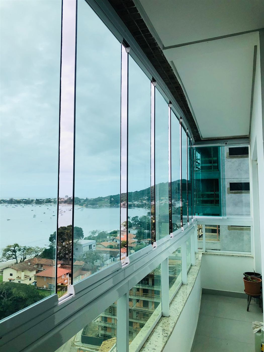 Envidraçamento de sacada curva com vista para a baía